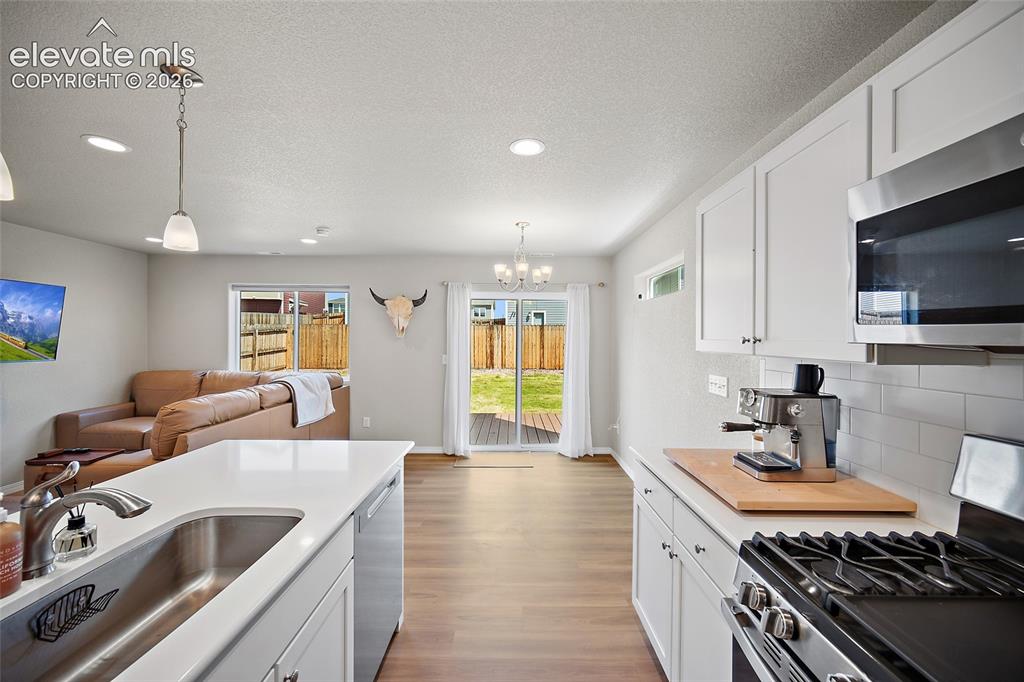 Image 10 of 40: Modern kitchen featuring white cabinetry, stainless steel appliances includ