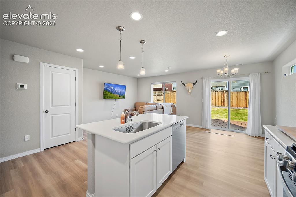 Image 11 of 40: Open-concept interior featuring light-toned wood-finish flooring, recessed