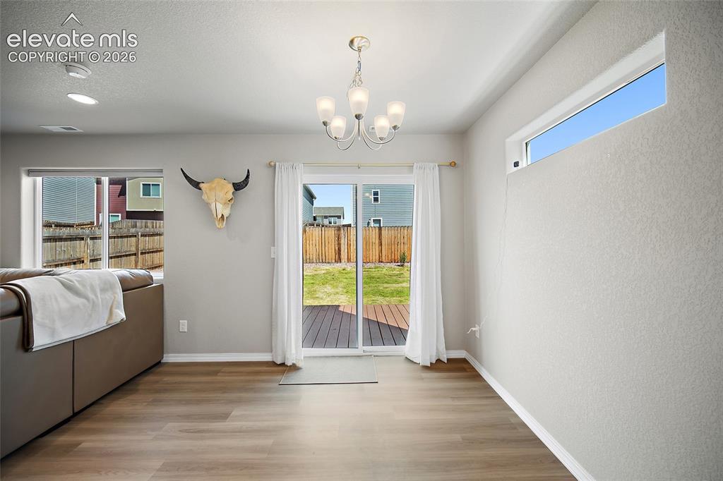 Image 12 of 40: Wood-finish flooring throughout, featuring a five-light chandelier, recesse