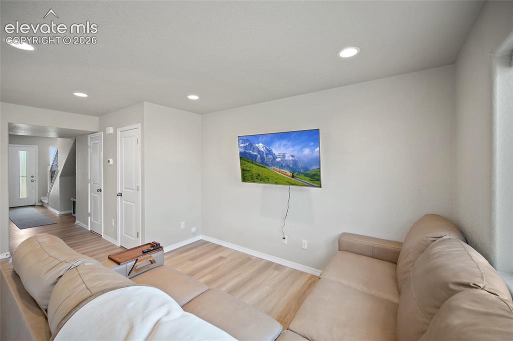 Image 14 of 40: Living area featuring recessed lighting, light-toned walls, and wood-finish