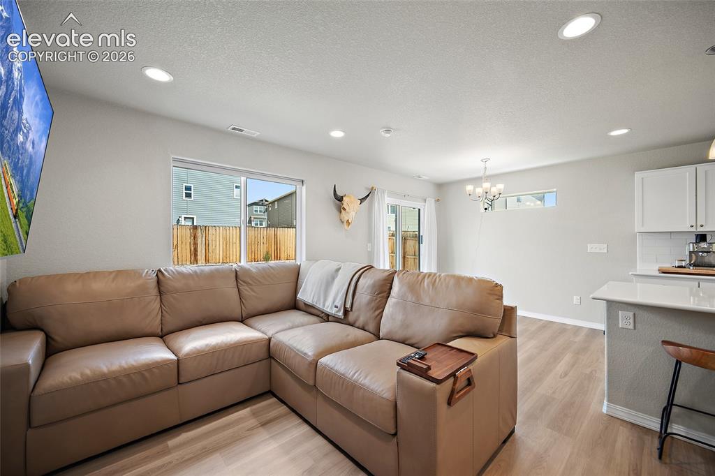 Image 15 of 40: Open-concept living space featuring wood-finish flooring, recessed lighting
