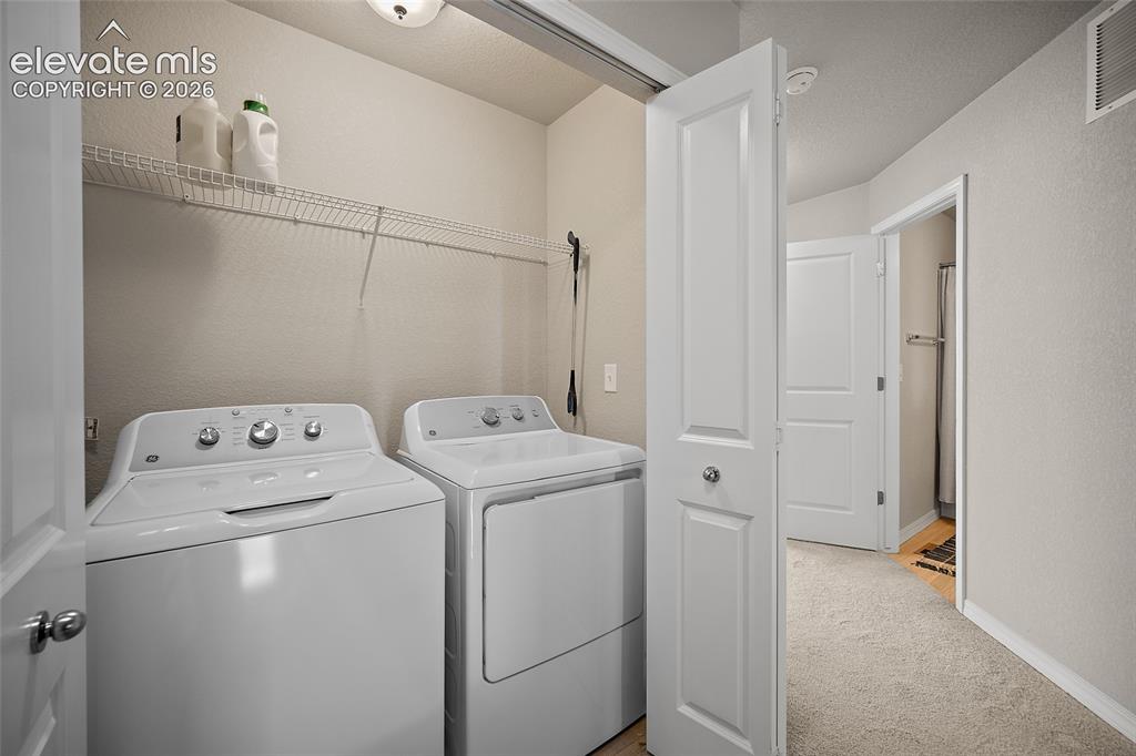 Image 18 of 40: Dedicated laundry area featuring a full-size washer and dryer