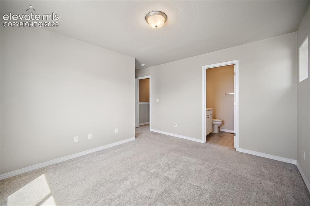 Image 26 of 40: Spacious interior room with light gray carpeting and white baseboards