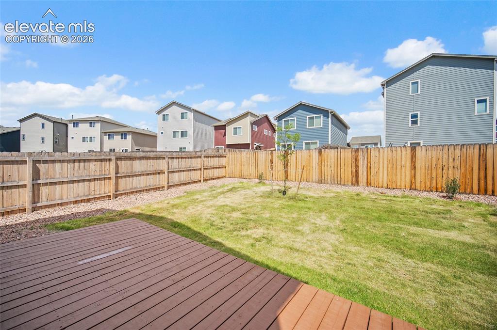 Image 29 of 40: Expansive backyard featuring a wood-finish deck, a natural wood privacy fen