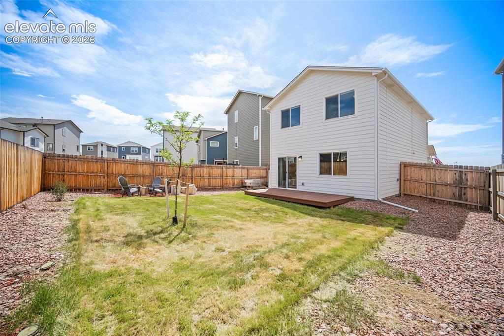 Image 31 of 40: Private backyard featuring a wooden privacy fence, a ground-level deck, and