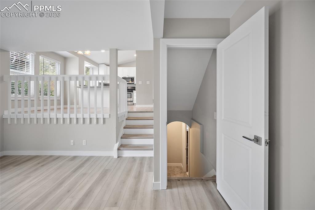 Image 16 of 36: Light wood-finish flooring extending into a bright room with white trim