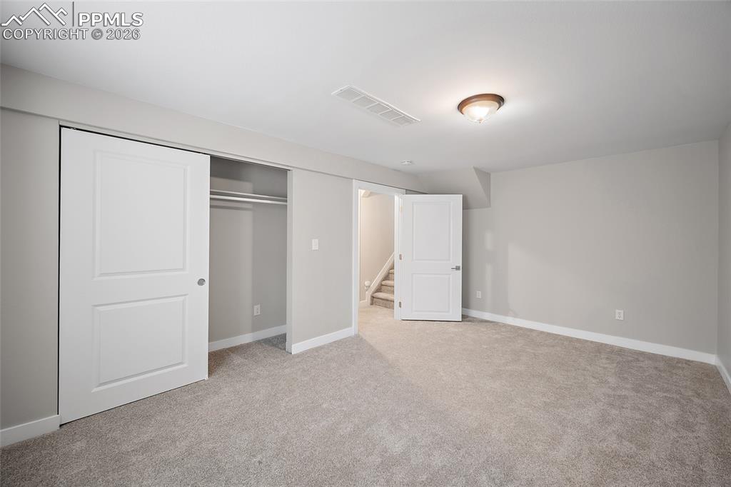 Image 18 of 36: Carpeted room featuring a white interior door, a bi-fold closet with white 