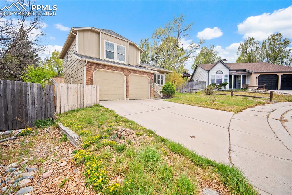 Image 2 of 36: Two-story exterior with a brick facade and tan siding