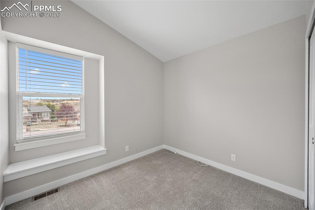 Image 21 of 36: Carpeted room with a large window featuring white blinds and a built-in win