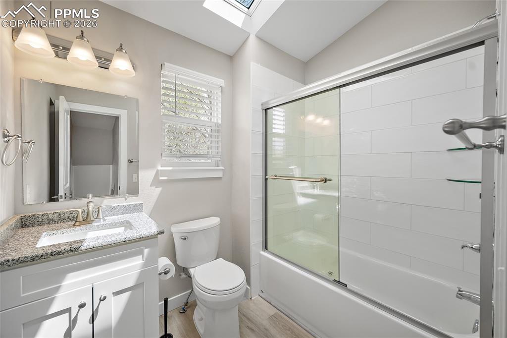 Image 23 of 36: Bathroom featuring a white vanity with a speckled countertop, a toilet, a w