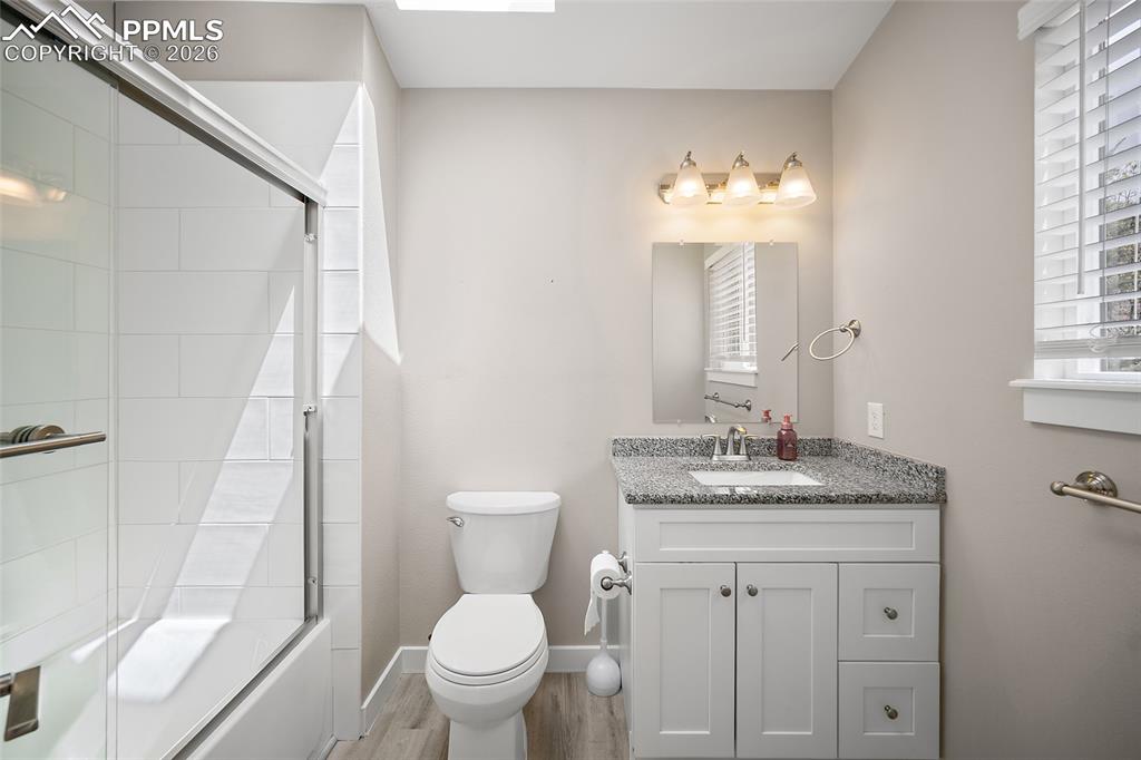 Image 27 of 36: Bathroom featuring a white vanity with a speckled countertop, a rectangular
