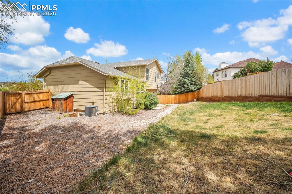 Image 31 of 36: Expansive backyard featuring a partial lawn, a gravel and mulch area, and a