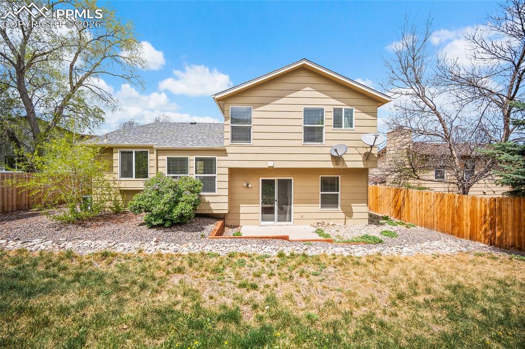 Image 32 of 36: Rear exterior featuring light-colored siding and a multi-level design