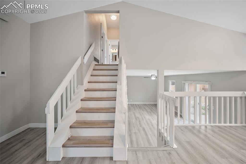 Image 6 of 36: Multi-level interior featuring a prominent staircase with white risers and 