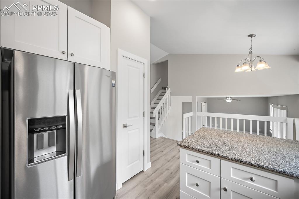Image 7 of 36: Kitchen featuring stainless steel refrigerator, white shaker-style cabinetr