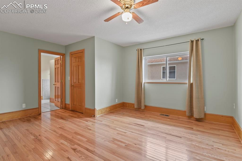 Image 18 of 37: Master Bedroom with wood-style flooring, ceiling fan, and Walk In Closet