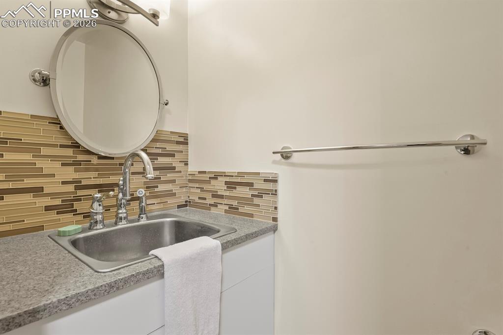 Image 22 of 37: Off Laundry Room is a 1/2 Bath with Deep Sink 