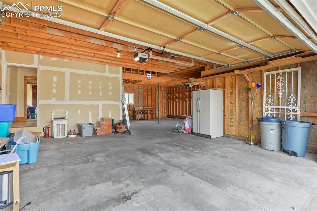 Image 29 of 37: Huge 800 sq ft Garage with two door openers and Work Area 