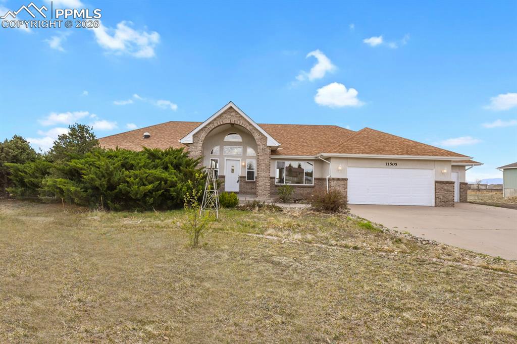 Image 37 of 37: View of front of house featuring an attached garage, brick siding, driveway