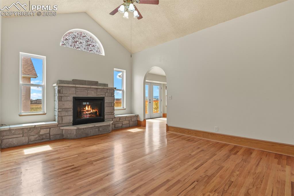 Image 4 of 37: Living room featuring a ceiling fan, arched walkways, light wood finished f