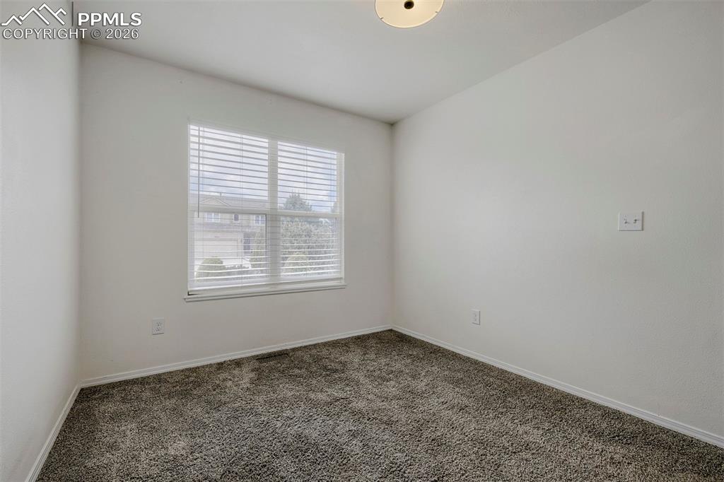 Image 11 of 32: Room featuring neutral wall tones, textured carpet flooring, a window with 