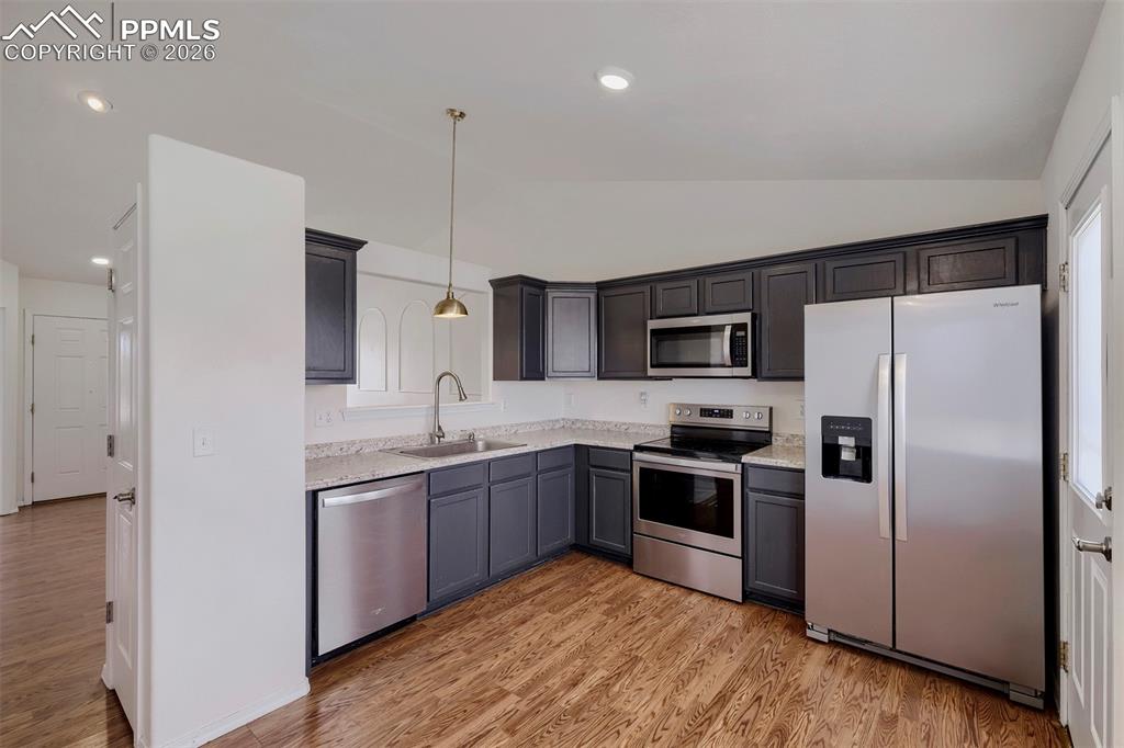 Image 15 of 32: Contemporary kitchen featuring dark cabinetry, stainless steel appliances, 
