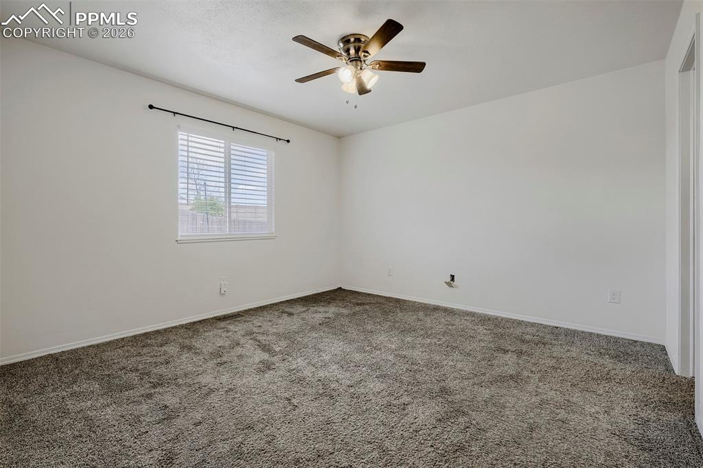 Image 17 of 32: Spacious room featuring neutral carpeting and light-colored walls