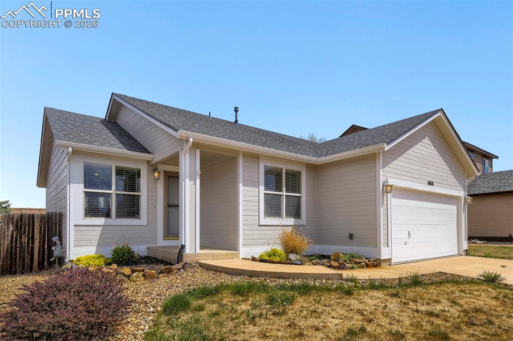 Image 2 of 32: Ranch-style residence featuring horizontal siding, a two-car garage, and a 