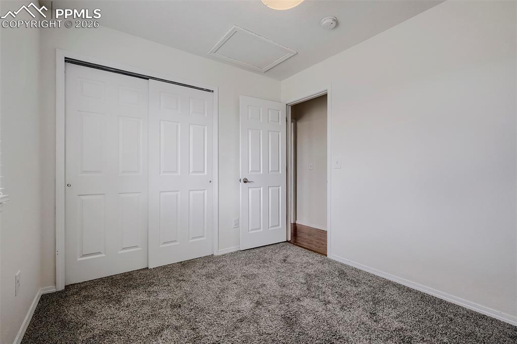 Image 23 of 32: Neutral tone interior featuring textured carpeting, white walls, and a matc