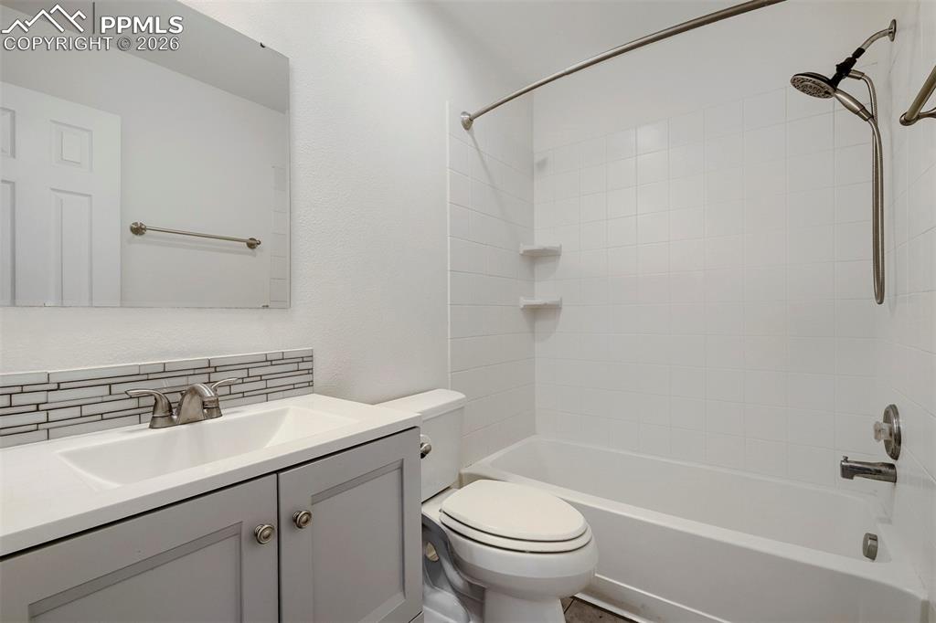 Image 25 of 32: Bathroom featuring a single vanity with a gray cabinet base, white countert