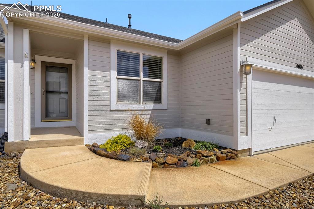 Image 3 of 32: Siding exterior with an attached garage, covered entryway, and a curved con