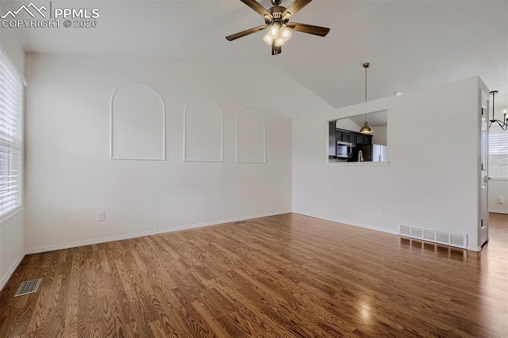 Image 5 of 32: Bright interior with wood-finish flooring, vaulted ceilings, and decorative