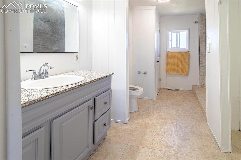 Image 12 of 38: Bathroom featuring vanity, toilet, and tile patterned flooring