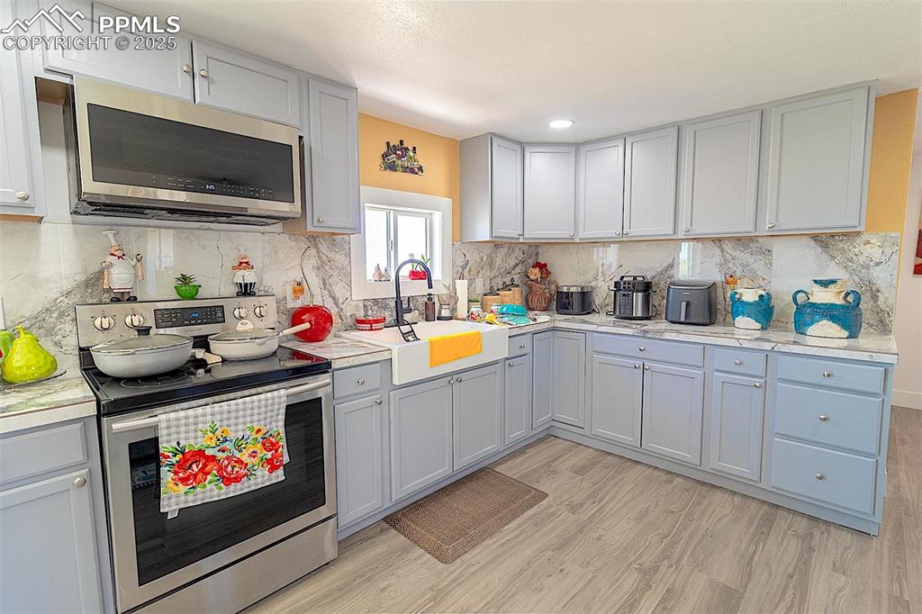Image 29 of 38: Kitchen featuring appliances with stainless steel finishes, a sink, light w