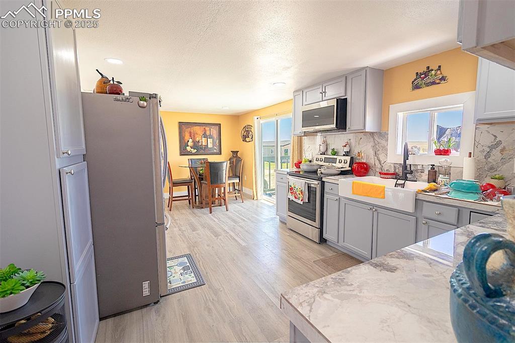 Image 30 of 38: Kitchen with appliances with stainless steel finishes, a sink, backsplash,