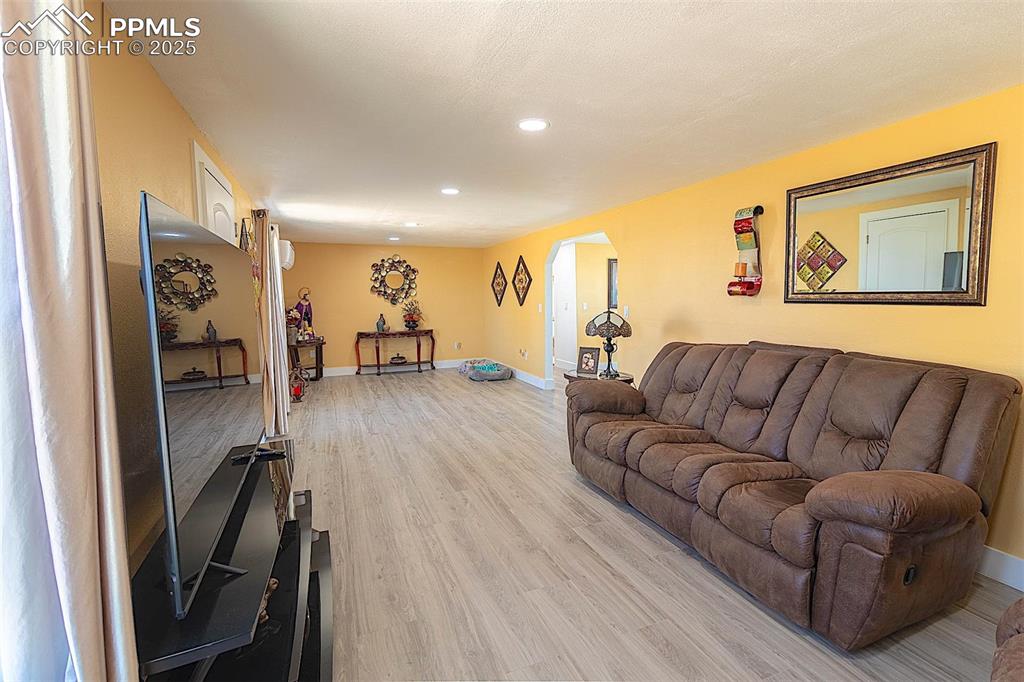 Image 32 of 38: Living room featuring recessed lighting, light wood-style floors, arched wa