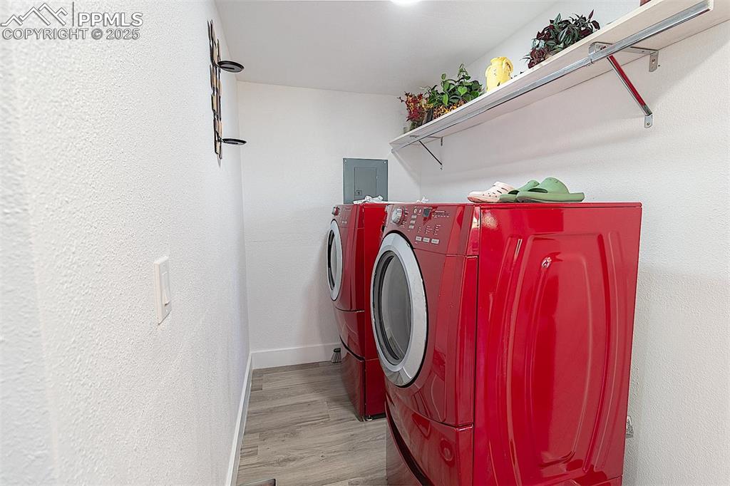 Image 33 of 38: Washroom with washing machine and dryer, wood finished floors, and baseboar