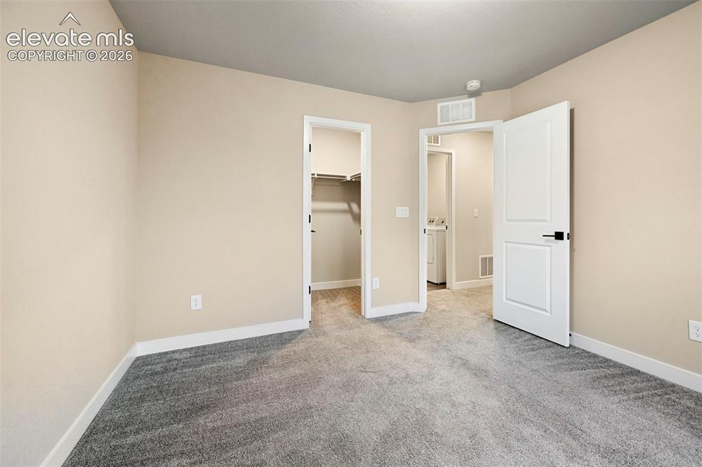 Image 11 of 28: Neutral-toned interior featuring plush gray carpeting and white baseboards