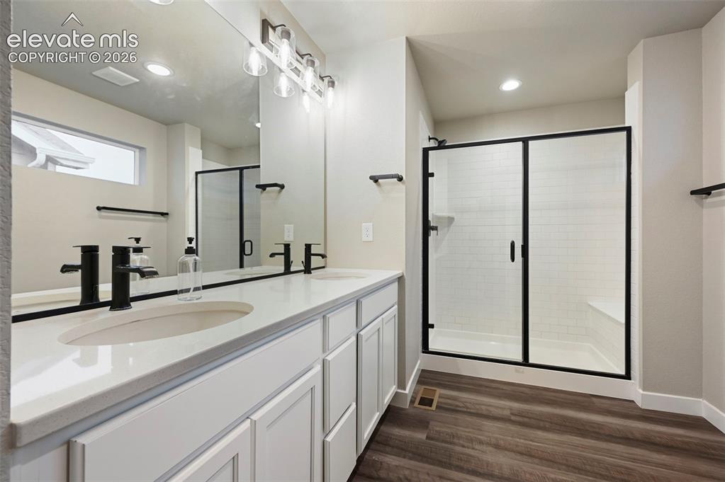 Image 20 of 28: Dual vanity with white cabinetry and integrated sinks, matte black fixtures