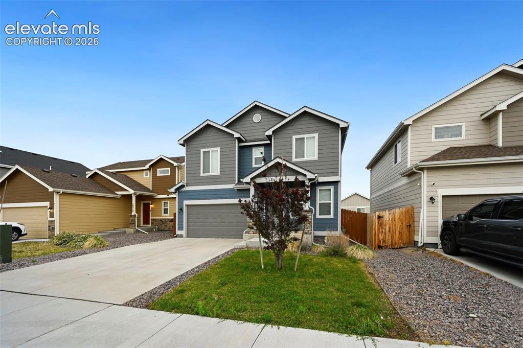 Image 25 of 28: Multi-level residence featuring gray and blue siding with white trim