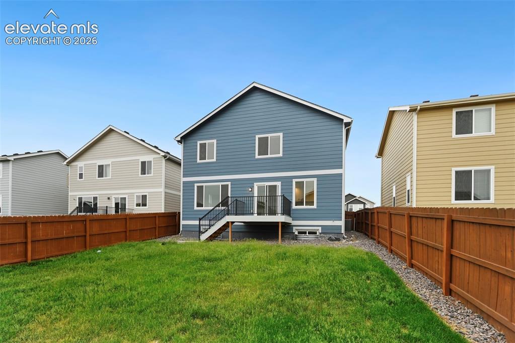 Image 28 of 28: Expansive green lawn with a newly installed brown privacy fence