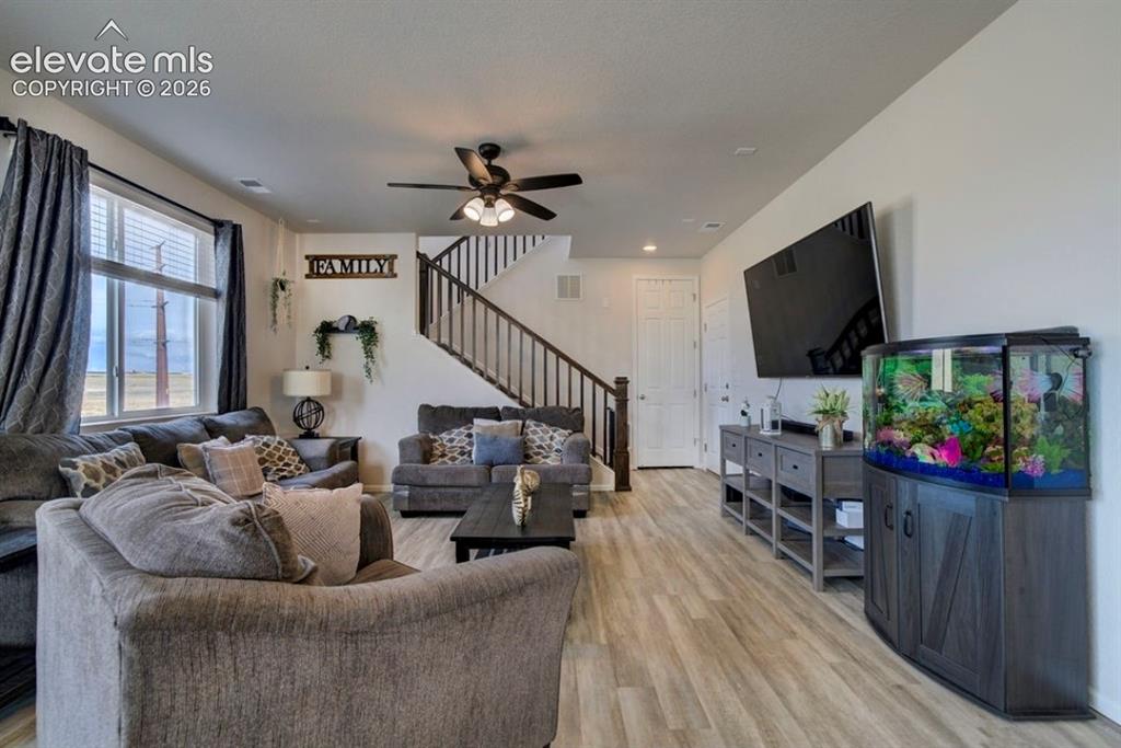 Image 13 of 34: Open-concept living space featuring wood-finish flooring, a contemporary ce