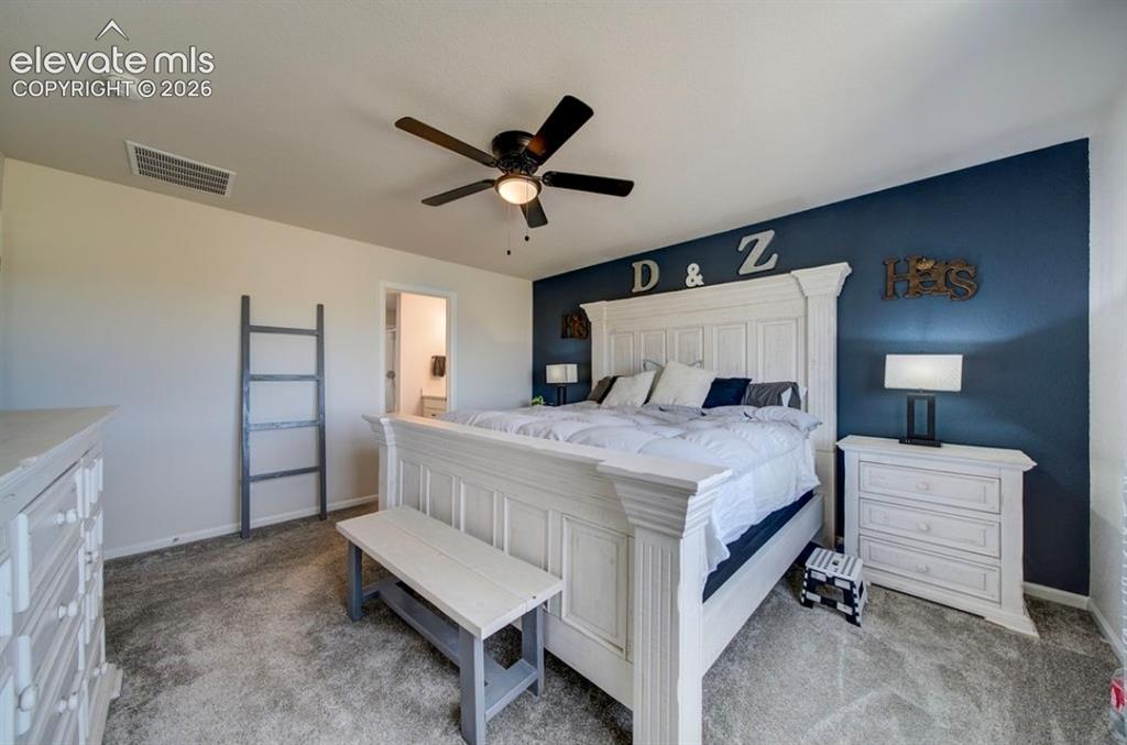 Image 18 of 34: Carpeted bedroom with a ceiling fan, accent wall, and recessed lighting