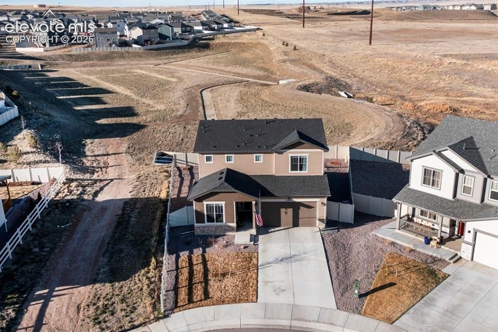 Image 2 of 34: Two-story residence with a two-car garage, concrete driveway, and a fenced 