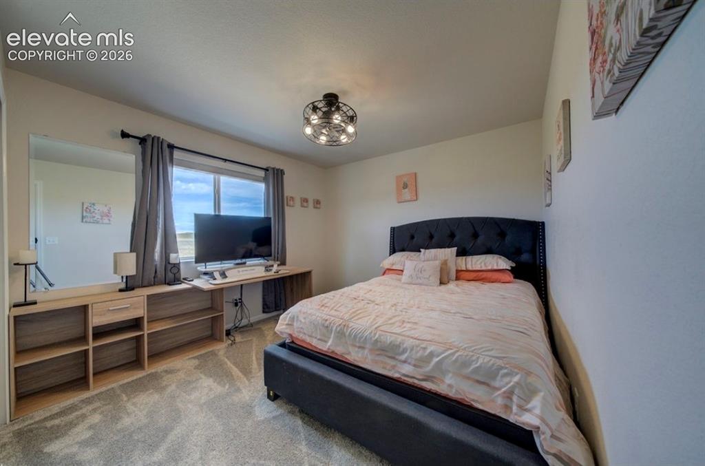 Image 22 of 34: Window with drapes, wall-mounted mirror, light-toned built-in shelving, tuf