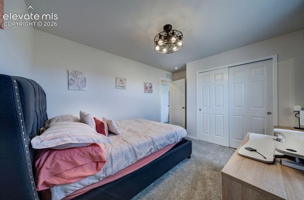 Image 23 of 34: Room featuring wall-to-wall carpeting, a multi-paneled double-door closet,