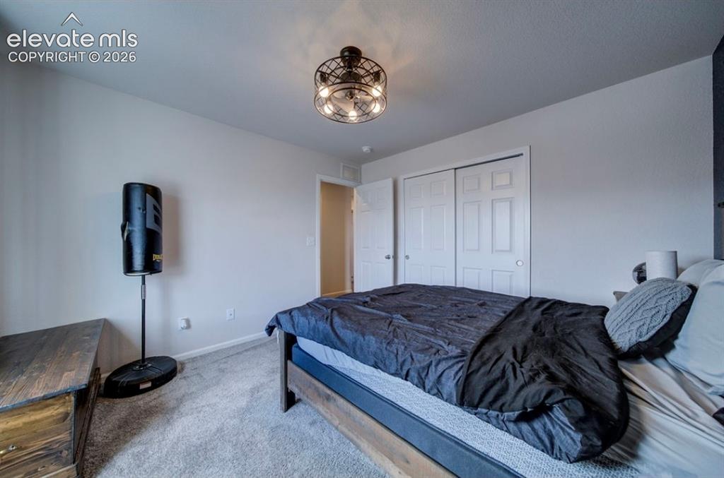 Image 25 of 34: Recessed lighting, textured carpeting, double bifold closet doors, and a mo