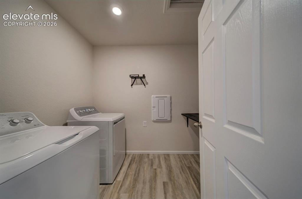 Image 26 of 34: Recessed ceiling lighting, wood-finish flooring, and a paneled door