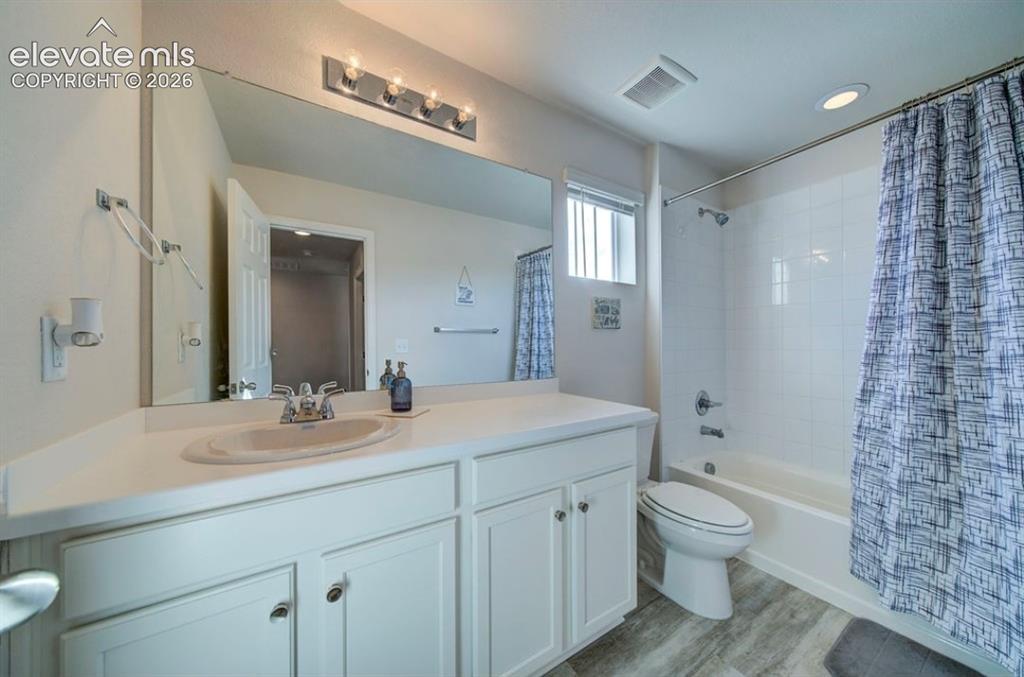 Image 27 of 34: White vanity with a single basin, stainless steel faucet, and overhead ligh