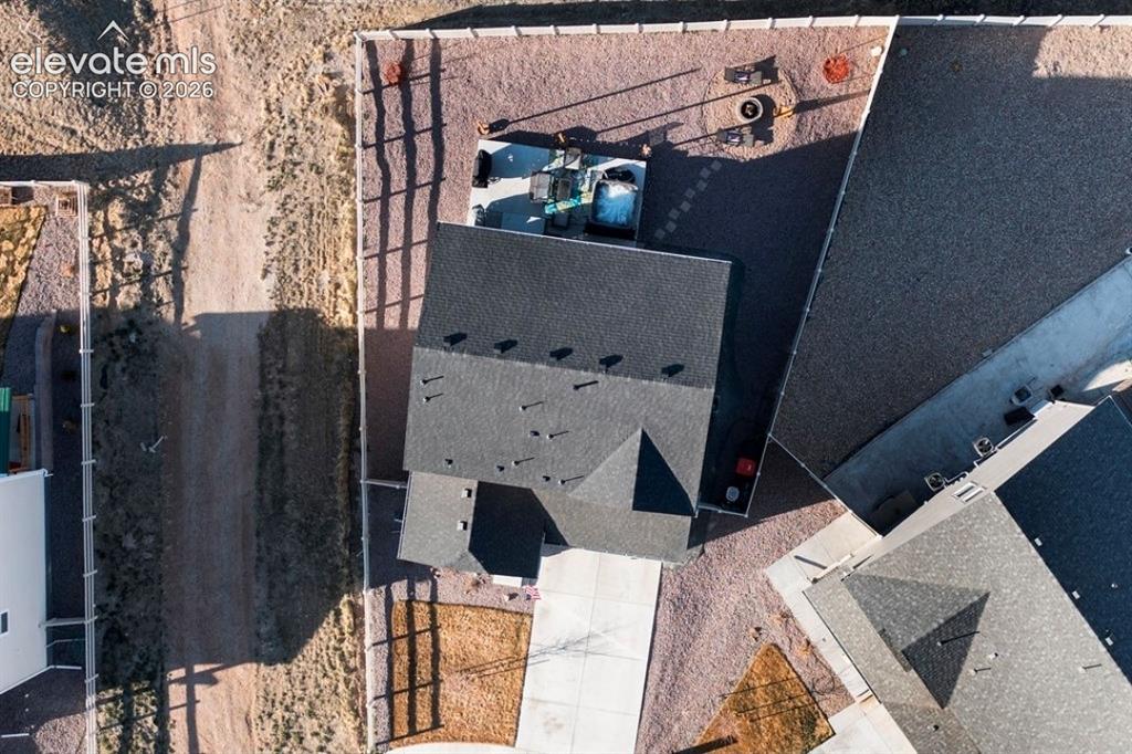 Image 3 of 34: Gabled roofline, light-colored concrete driveway, gravel landscaping, perim